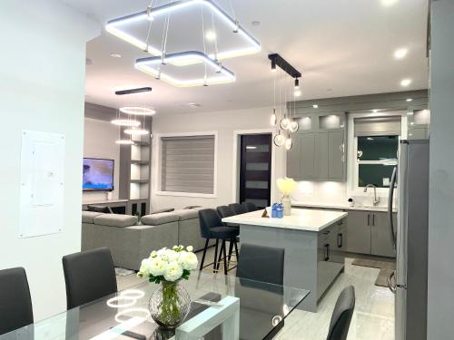 a kitchen and living room with a couch and a table at Modern and New house near PNE with Big Garden and Free Parking in Vancouver
