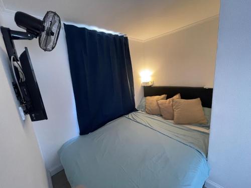 羅馬的住宿－Little Aventino BnB，小卧室配有一张带蓝色窗帘的床