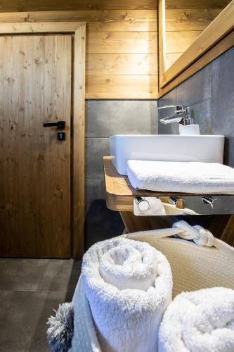 a bathroom with a sink and a bed with towels at Domki Fox House z jacuzzi elektrycznym na wyłączność in Kościelisko