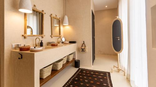 een badkamer met een wastafel en een spiegel bij Villa Ecolodge DAR LOUMA in Marrakesh