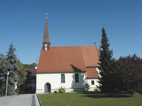 eine kleine weiße Kirche mit Kirchturm und Turm in der Unterkunft Osternacherhof in Osternach
