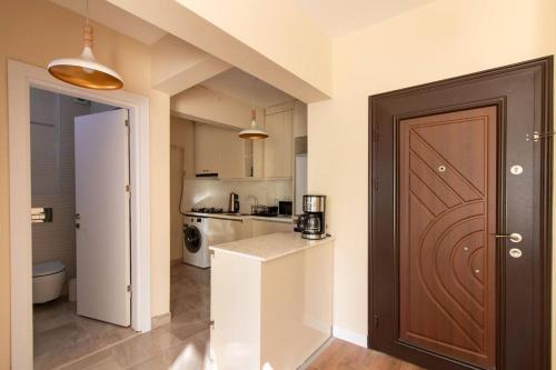 a kitchen with a counter and a door in a room at Cozy & Complete 1BR Retreat w/ Balcony in Istanbul