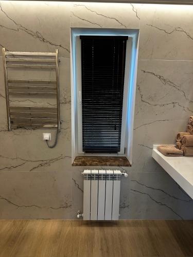 a bathroom with a window and a radiator at Park-Hotel Tihiy Les in Prokhorovka