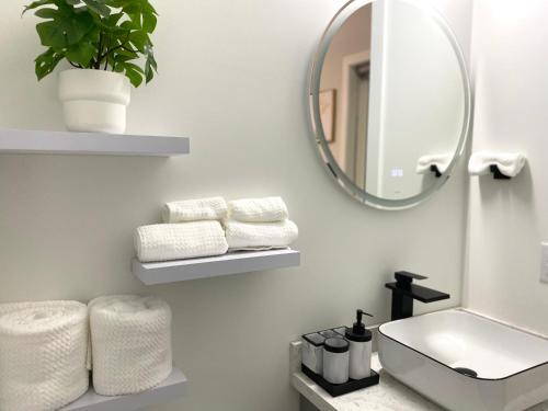 a bathroom with a sink and a mirror and towels at Modern and New house near PNE with Big Garden and Free Parking in Vancouver