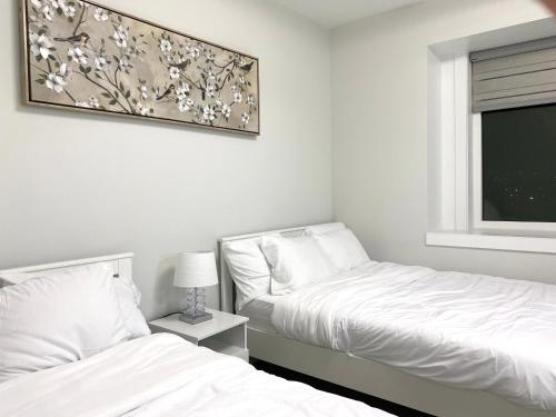 1 dormitorio con 2 camas y una foto en la pared en Modern and New house near PNE, en Vancouver