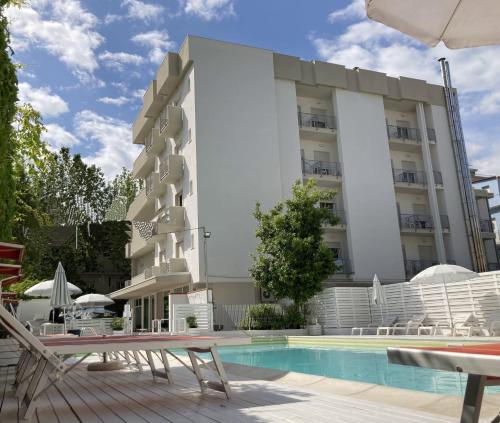 a hotel with a swimming pool in front of a building at Hotel Villa del Parco in Rimini