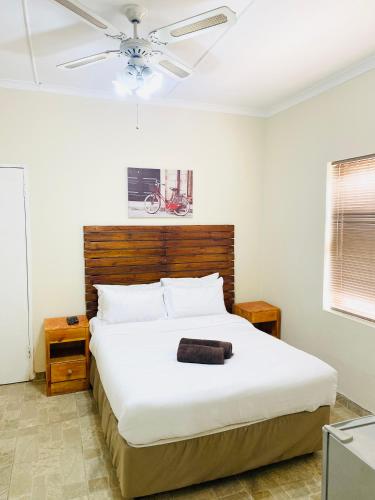 a bedroom with a large bed with a ceiling fan at Comfort Home Guest House in East London