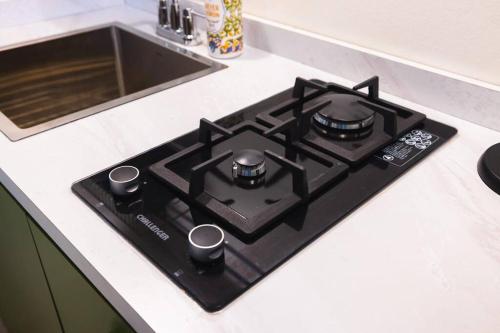 a black stove top in a kitchen next to a sink at Catania 2 Suite W/private pool,W/heater , WIFI. in Aguadilla