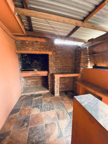 a room with a brick wall and a fireplace at Comfort Home Guest House in East London
