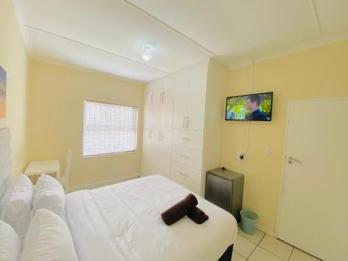 um quarto com uma cama e uma televisão na parede em Comfort Home and Comfort Zone BnB em East London