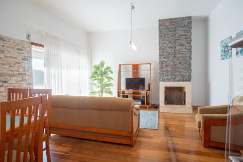 a living room with a couch and a fireplace at 8 Rodrigues Family House - Villa with patio in Nazaré