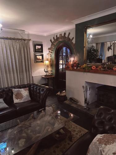 a living room with a leather couch and a fireplace at East Ayton Lodge Hotel, Scarborough in Scarborough