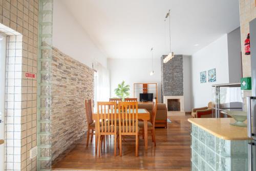 a dining room and living room with a table and chairs at 8 Rodrigues Family House - Villa with patio in Nazaré