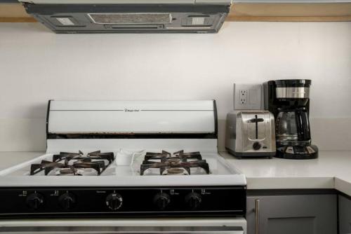 La cocina está equipada con fogones blancos. en Beautiful 2BR unit in the heart of K-Town, en Los Ángeles