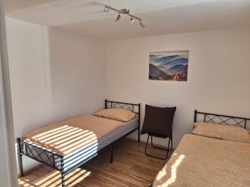 a room with two beds and a chair in it at Apartment Rheintal im Alpenvorland in Batschuns