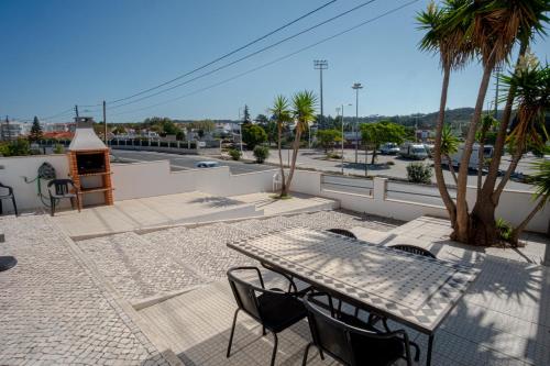 a patio with a table and chairs on a balcony at 8 Rodrigues Family House - Villa with patio in Nazaré