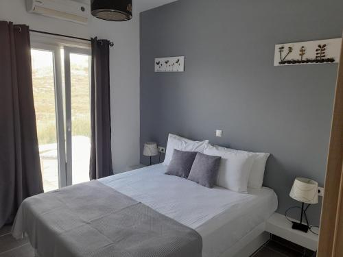 a bedroom with a large bed with a window at Romantic House Sea View Adults only in Ios Chora