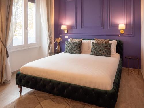1 dormitorio con 1 cama grande y paredes moradas en Alto Apartment, en Roma