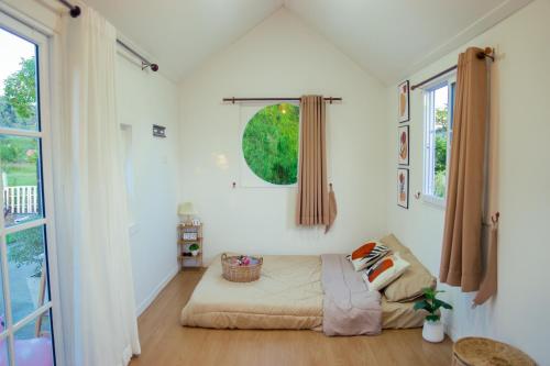 1 dormitorio con 1 cama en una habitación con ventanas en CannaGarden2, en Ban Khok