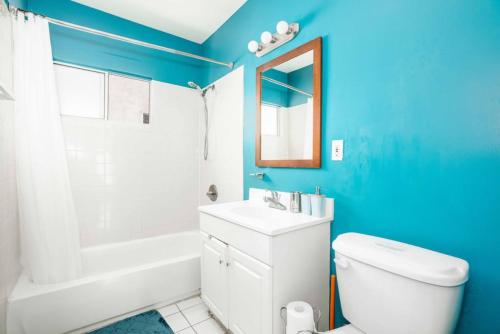 een badkamer met een wit toilet en een blauwe muur bij Delightful 1BR home in the Heart of K-Town in Los Angeles