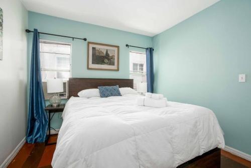een slaapkamer met een groot wit bed met blauwe muren bij Delightful 1BR home in the Heart of K-Town in Los Angeles