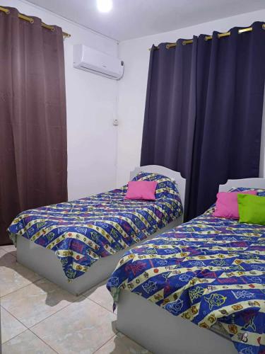 2 Betten nebeneinander in einem Zimmer in der Unterkunft Résidence Lennards 2 in Grand Baie
