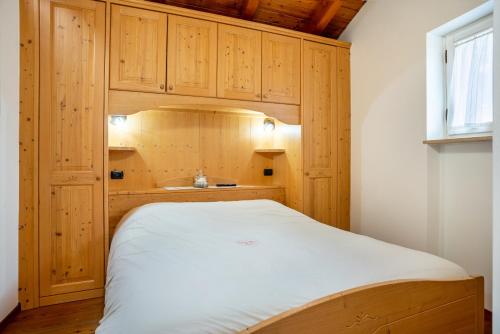 a small bedroom with a bed with wooden cabinets at Emma Home in Mezzolombardo