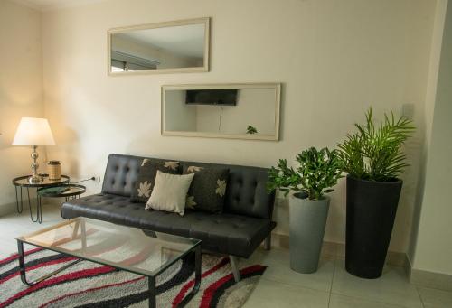 sala de estar con sofá negro y espejo en DEPTO CASEROS en Salta