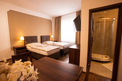 a hotel room with two beds and a shower at CORNER HOUSE in Lučenec