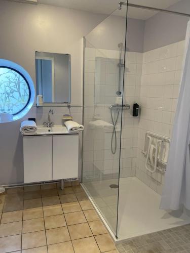 a bathroom with a shower and a sink at Logis Hôtel Le Keréden in Locarn