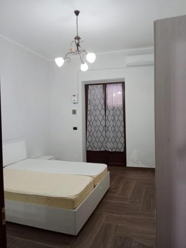 um quarto branco com uma cama e uma janela em Trotskyhouse em Campobello di Licata