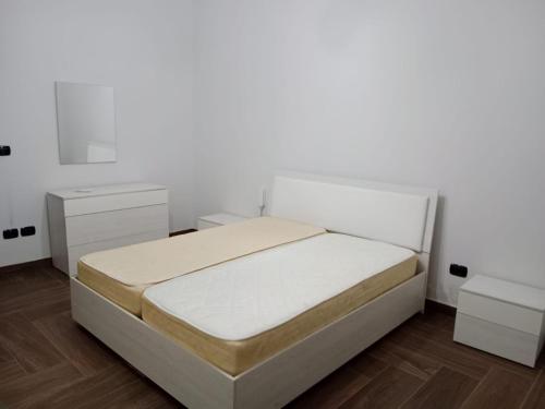 um quarto branco com uma cama e duas mesas de cabeceira em Trotskyhouse em Campobello di Licata