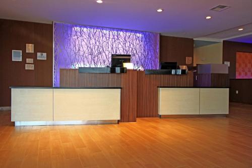a lobby with two reception desks and a purple screen at Fairfield Inn & Suites by Marriott London in London