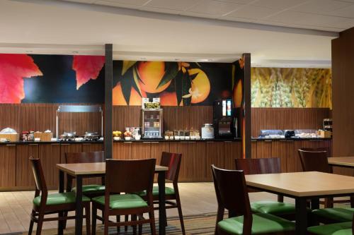 ein Restaurant mit Tischen und Stühlen und eine Bar in der Unterkunft Fairfield Inn & Suites by Marriott London in London