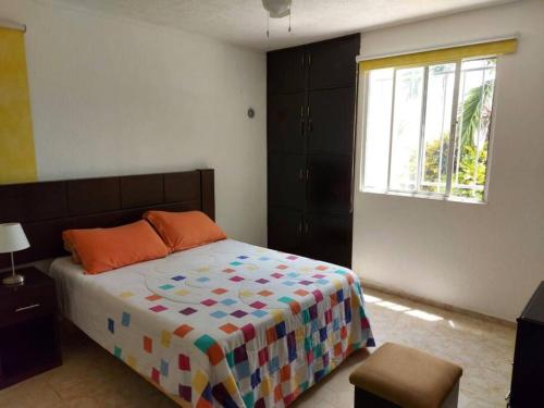 a bedroom with a bed and a window at Rincón Maya, hospedaje hasta para 16 personas in Mérida