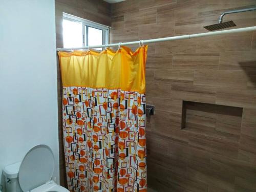 a shower curtain in a bathroom with a toilet at Rincón Maya, hospedaje hasta para 16 personas in Mérida