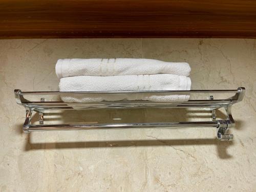 three towels on a towel rack in a bathroom at Tekri Farms and Retreat in Ujjain