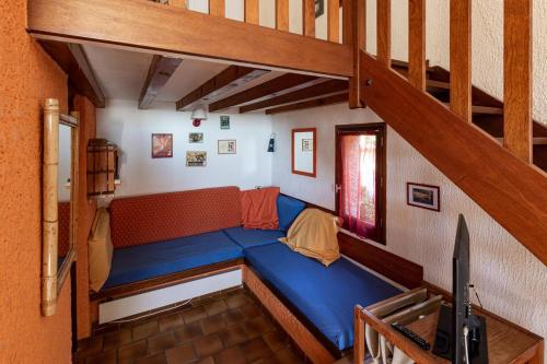 um grande sofá azul num quarto com uma escada em Bastidon Avec Terrasse Vue Mer em Carqueiranne