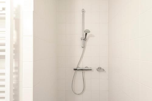 a shower with a shower head in a bathroom at Kaag Resort in Warmond