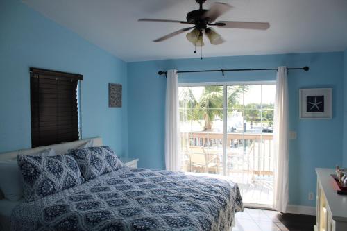 a bedroom with a bed and a ceiling fan at Tropical Cottages in Marathon