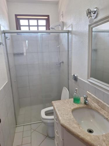 a bathroom with a shower and a sink and a toilet at Apartamento na Barra de Ibiraquera in Imbituba
