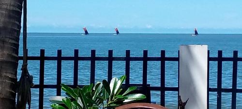 two sail boats in the ocean with a fence at Winston Sea Front Villa in Negombo