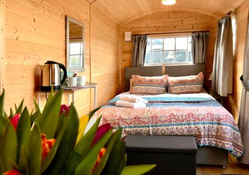 a bedroom with a bed in a wooden cabin at Arniss Lodge in Fordingbridge