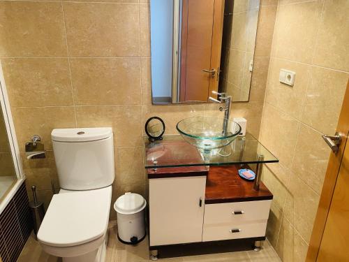 a bathroom with a toilet and a sink and a mirror at Anacasa Albatros MET Oliva Nova Golf AP463 in Oliva