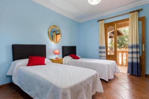 twee bedden in een kamer met blauwe muren bij Villa Son Tugores in Lloseta