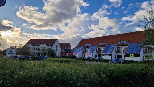 a row of houses with blue roofs and parked cars at Vissershuisje 89 te Wenduine in Wenduine