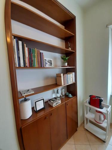 una estantería de madera con libros. en A casa di Ciccio da'mmonte, en Velletri