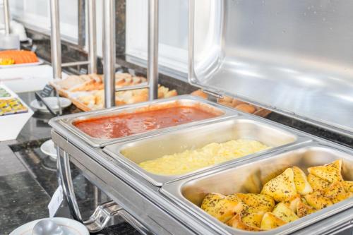 a refrigerator filled with different types of food at Foz Fronteira Hotel in Foz do Iguaçu