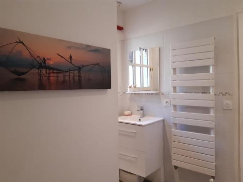 ヴェリエ・デュ・ラックにあるMaison avec Piscine LAC d'ANNECY - proximité Plage VEYRIER DU LACの洗面台付きのバスルーム、壁に絵画