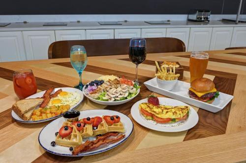 a table with plates of food and glasses of wine at Four Points by Sheraton Birmingham Homewood in Homewood